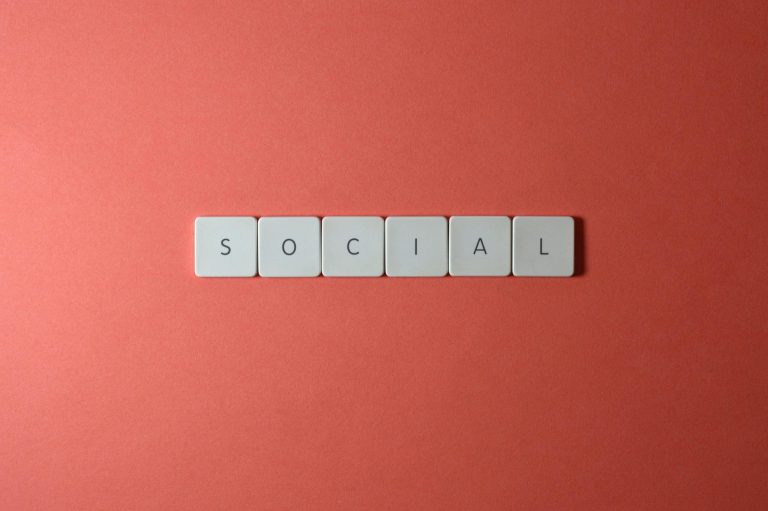 Close-up of the word 'SOCIAL' formed with tiles on a red surface, offering copyspace.